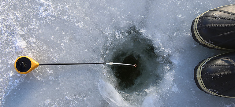 Hole in the ice, fishing line in the hole, boots to the side, email phishing abstract
