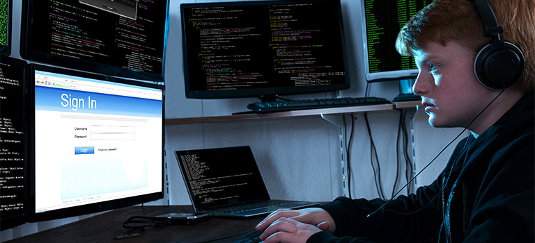 Script Kiddie hacking in a dark room, multi computer set up, young hacker